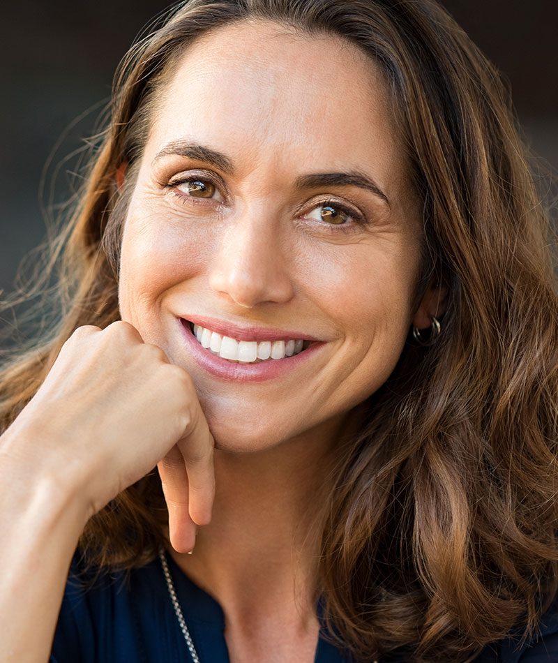 Woman smiling and resting her face on her hand