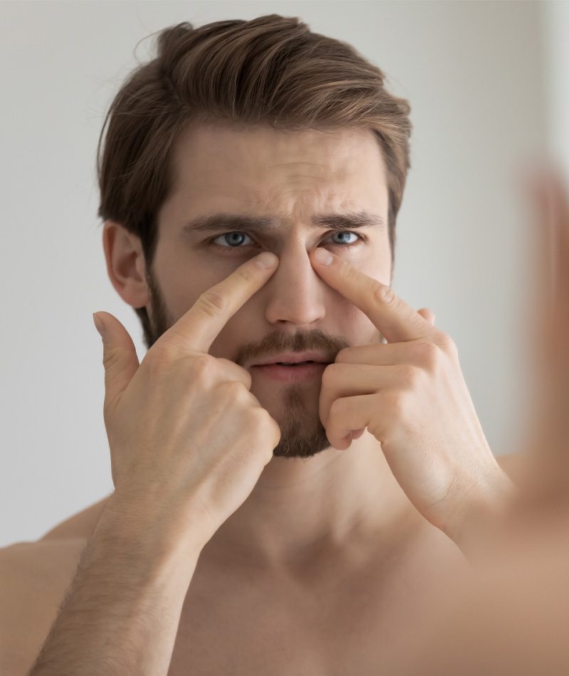 Handsome young man touching his nose