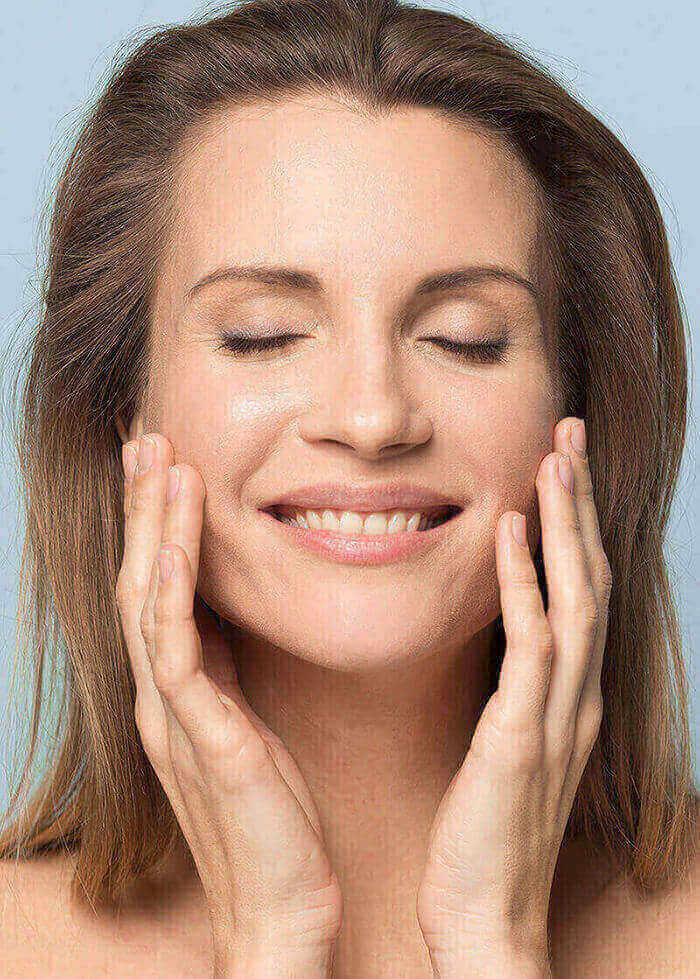 Woman with eyes closed touching face