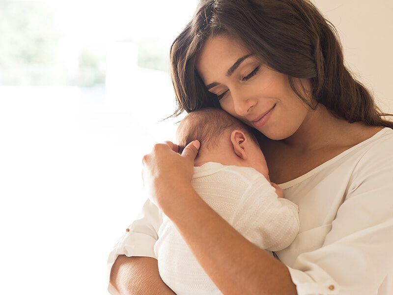 Mother sweetly holding her newborn